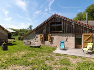 a wooden house with a patio and a bench at Gîte nature & confort rénové, Plateau des 1000 étangs - WIFI, parking - FR-1-583-302 in Saint-Bresson