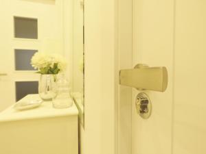 una puerta de baño con un jarrón de flores en un mostrador en Pension Mayte, en Pamplona