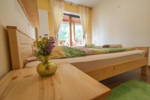 a room with a bed with a vase on a table at Tourist Farm Pri Kafolu in Tolmin