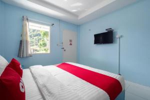 - une chambre bleue dotée d'un lit avec une couverture rouge et blanche dans l'établissement OYO 1133 Koh Chang Baantalay Resort, à Ko Chang