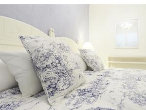 uma cama com lençóis e almofadas azuis e brancos em Pension Mayte em Pamplona