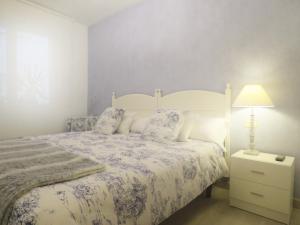 Un dormitorio con una cama y una lámpara en una mesita de noche. en Pension Mayte, en Pamplona