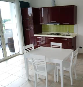 cocina con mesa blanca y sillas blancas en Guest House Residence Malpensa, en Case Nuove