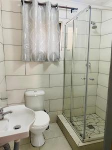 a bathroom with a toilet and a shower and a sink at Ikhaya Guesthouse in Empangeni +13 photos