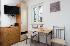a small dining room with a table and a tv at La Perla Luxury Apartments in Split