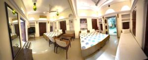 a room with two beds and a table and chairs at Natraj Guest House in Ajmer