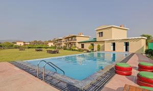 una grande piscina davanti a una casa di Corbett The Serene By Sukhmani Resorts a Ramnagar