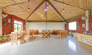 una sala da pranzo con tavoli e sedie in legno di Corbett The Serene By Sukhmani Resorts a Ramnagar