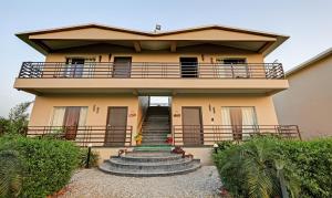 una casa con un balcone in cima di Corbett The Serene By Sukhmani Resorts a Ramnagar