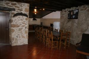 een keuken en eetkamer met een tafel en stoelen bij Abrigo de Montanha in Montalegre