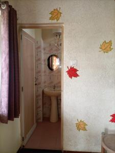 a bathroom with a sink and autumn leaves on the wall at Banolata Lakeside Homestay by StayApart in Damanpur