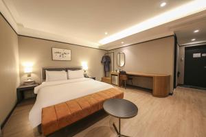 a hotel room with a large bed and a desk at Browndot Hotel Deokjin in Jeonju