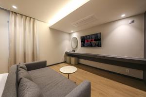 a living room with a couch and a table at Browndot Hotel Deokjin in Jeonju