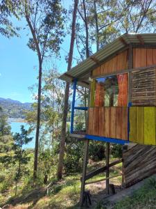 a tree house in the woods next to a lake at CABAÑA REFUGIO Rodeada de naturaleza y espectacular vista al embalse del Guavio in Las Lagunas +1 photo