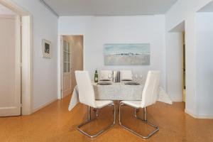 a dining room with a table and white chairs at Arenyslux in Arenys de Mar
