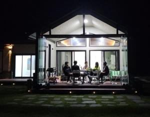 a group of people sitting at a table in a house at Cheongna Stay in Boryeong