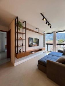 a living room with a bed and a tv at Apto lindo nas montanhas! in Venda Nova do Imigrante