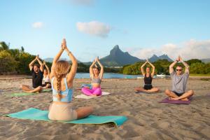 a group of people doing yoga on the beach at Summerdays Studios in Coteau Raffin