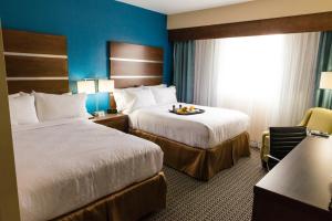 una habitación de hotel con 2 camas y una silla en Holiday Inn Houston Downtown, an IHG Hotel, en Houston
