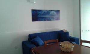 a living room with a blue couch and a table at Appartamento Shabby Chic in Trapani