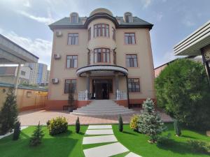 un gran edificio rosa con una escalera delante en HOTEL DEHLAVI o, en Dushanbe