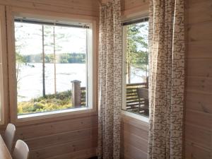 two windows in a room with a view of a lake at Ankkuri Raijan Aitta in Mikkeli