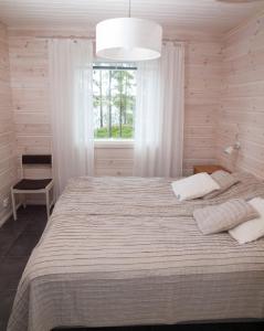 a bedroom with a large bed with a window at Ankkuri Raijan Aitta in Mikkeli