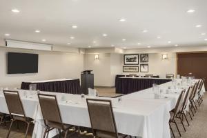 a conference room with white tables and chairs and a screen at Country Inn & Suites by Radisson, Ames, IA in Ames