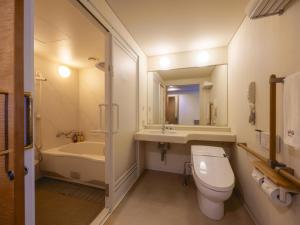 a bathroom with a toilet and a sink and a tub at Kansai Airport Washington Hotel in Izumi-Sano