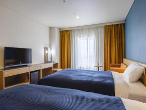 a hotel room with two beds and a flat screen tv at Kansai Airport Washington Hotel in Izumi-Sano +37 photos