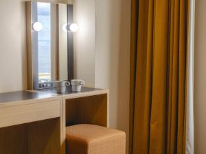 a dressing room with a mirror and a chair at Kansai Airport Washington Hotel in Izumi-Sano