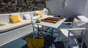 a room with a table and a couch and chairs at Heliades Apartments in Imerovigli