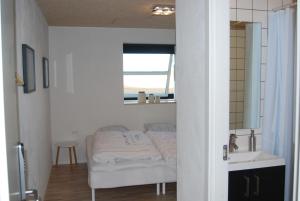 a bed in a room with a mirror and a sink at Rind B&B in Herning