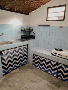 eine Küche mit blau-weißen Fliesen und einer Spüle in der Unterkunft SakaLoka Heritage in Timuran