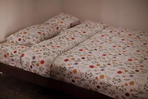 ein Bett mit einer Bettdecke und Blumen darauf in der Unterkunft SakaLoka Heritage in Timuran