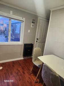 a room with a table and chairs and a window at Cabaña Full Equipada Sector Norte in Punta Arenas