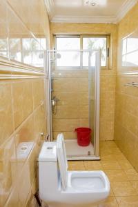 une salle de bain avec une douche, des toilettes et un lavabo dans l'établissement WOODLAND CENTER APARTMENTs, à Kigali
