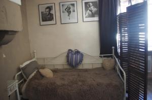 a bed in a room with pictures on the wall at Gite Du Passant Rennais avec balcon sur cour in Rennes
