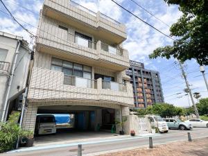 een hoog bakstenen gebouw met een parkeergarage bij Marina Bay Atami in Atami