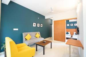 a living room with a couch and a table at Hotel O Executive Stays Yelahanka New Town in Bengaluru