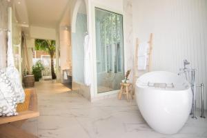 a bathroom with a large bath tub in a room at Malahini Kuda Bandos Resort in North Male Atoll