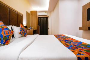 a hotel room with a large bed with colorful pillows at FabHotel Atithi Residency I - Nr BKC in Mumbai