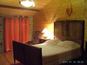 a bedroom with a bed in a wooden room at Cellier de la Fontaine in Saint-Georges-en-Couzan