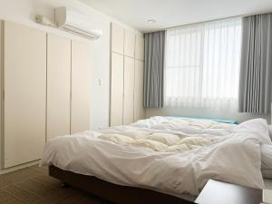 Een bed of bedden in een kamer bij Marina Bay Atami