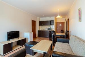 a living room with a couch and a table and a kitchen at Midia Holiday Apartments in Aheloy