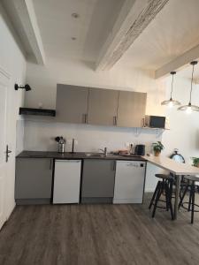 a kitchen with white cabinets and a table at Bon Pasteur in Aix-en-Provence +1 photo
