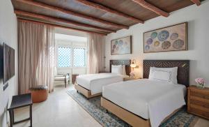 Rúm í herbergi á Hilton Salwa Beach Resort and Villas