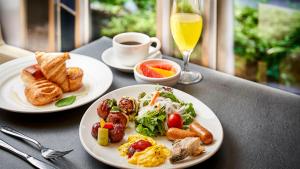 una mesa con dos platos de desayuno y un vaso de zumo de naranja en Daiwa Roynet Hotel Osaka Yotsubashi, en Osaka