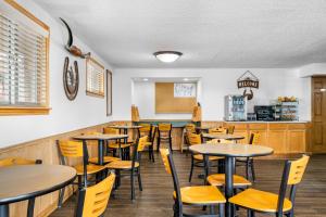 a dining room with tables and yellow chairs at Econo Lodge in Miles City