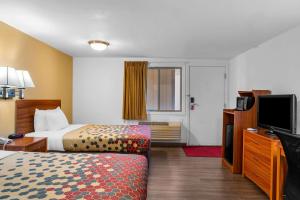 a hotel room with a bed and a flat screen tv at Econo Lodge in Miles City